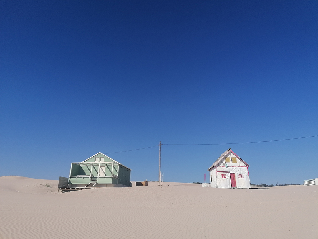 Coastal landscape with traditional houses and natural surroundings highlighting the balance between tourism and nature